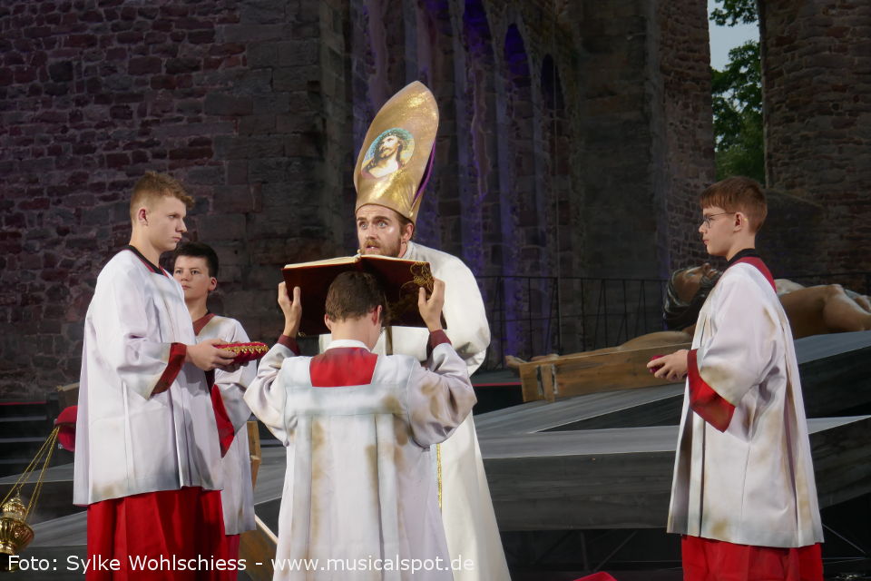 November 2021: Papst Franziskus hält im Petersdom eine Messe vor Jugendlichen. Er ermutigt sie, „Baumeister inmitten von Trümmern zu sein, fähig zu träumen“. Viele Träume der jungen Menschen entsprächen den Träumen Jesu für die Menschheit. Diese Szene stellt Regisseur Stefan Huber vor den eigentlichen Beginn des Musicals. Doch von „Geschwisterlichkeit, Solidarität, Gerechtigkeit, Frieden“ ist die Welt und auch die Geistlichkeit weit entfernt. Kirchenaustritte und Skandale statt Glaube, Liebe und Hoffnung. Doch wie nahm das Christentum seinen Anfang? Blättern wir in der Bibel - oder - gehen wir in der Bad Hersfelder Stiftsruine mit dem Webber/Rice-Musical „Jesus Christ Superstar“ zurück, bis ungefähr in das Jahr 33 n.Chr, in das Land Judäa… jesus christ superstar musical bad hersfeld 01